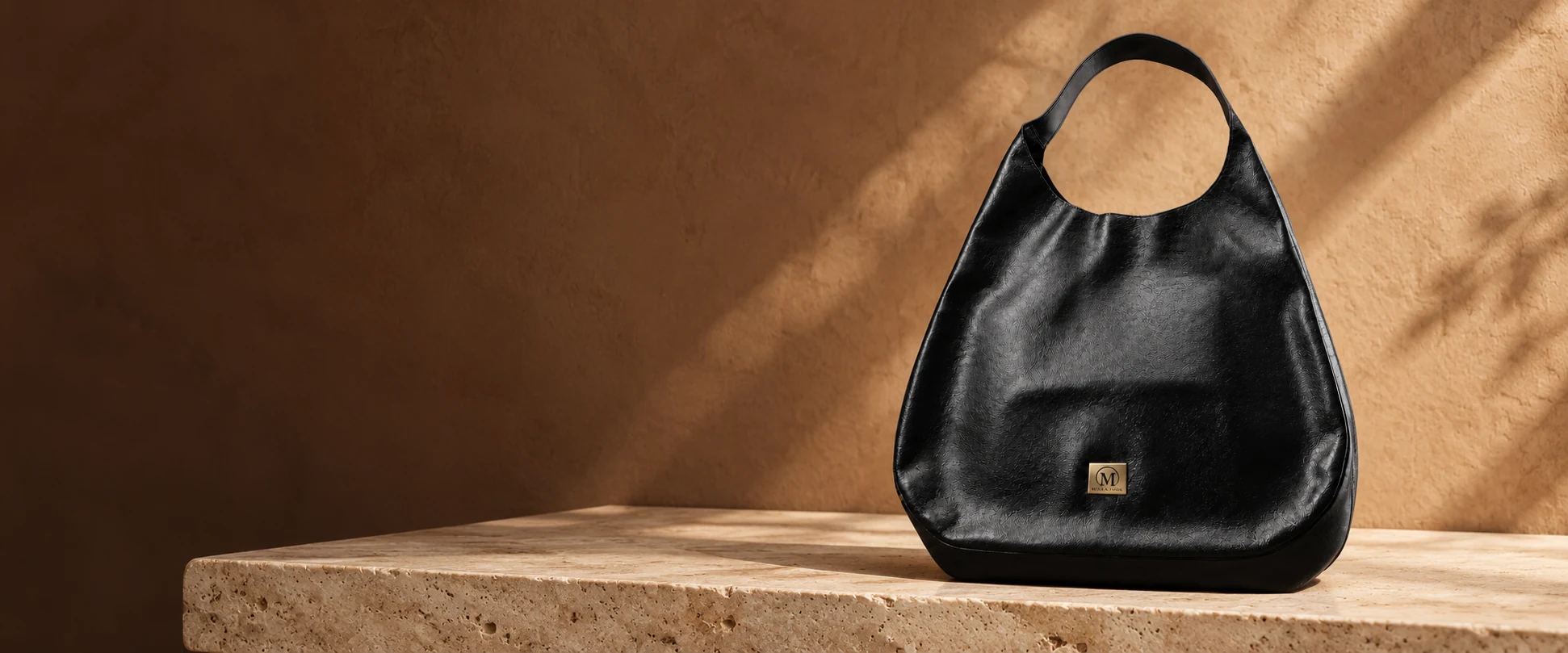 Oversized Leather Hobo Bag displayed on a travertine shelf against clay-coloured plaster