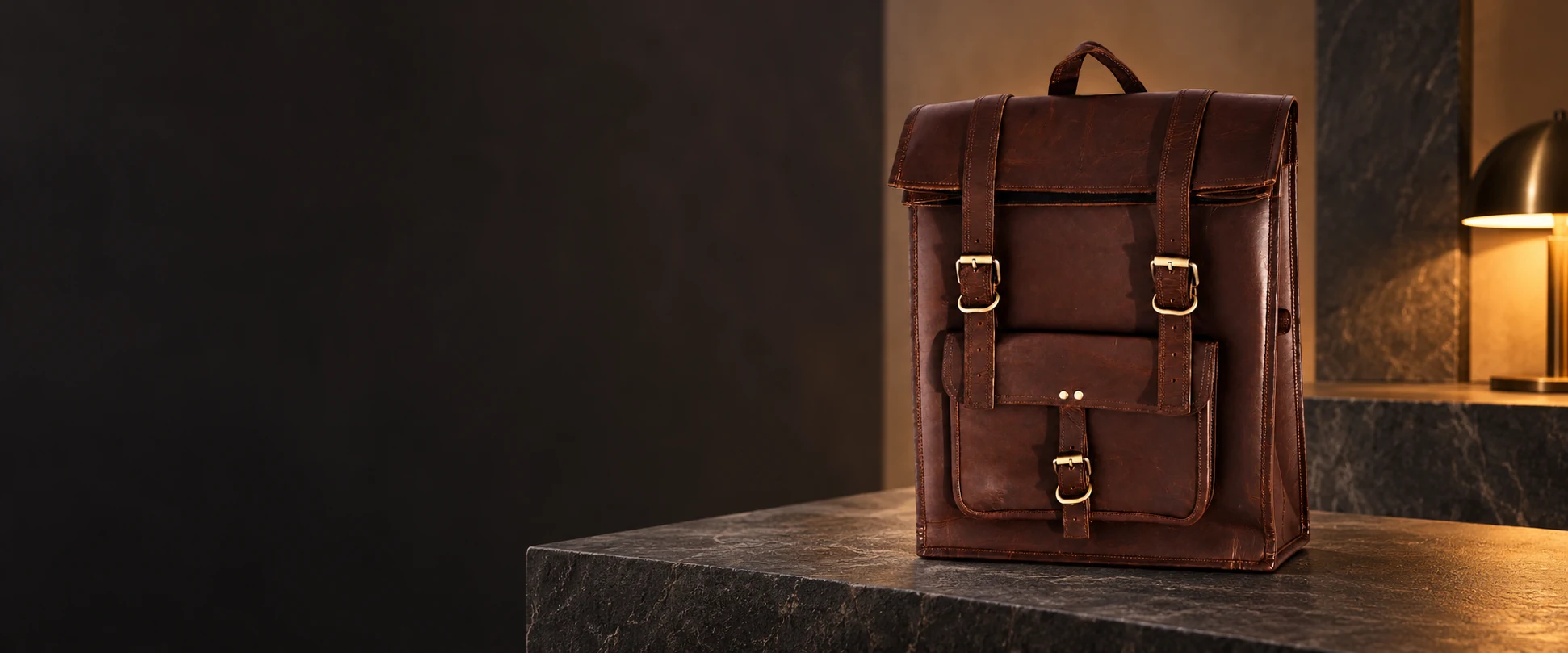 Leather Flap Backpack displayed on a charcoal stone display in a leather showroom