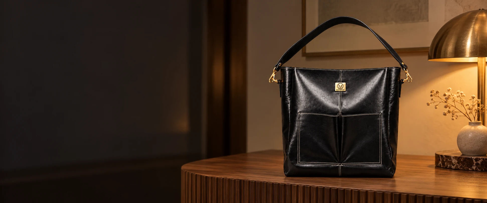 Double-Pocket Leather Tote Bag displayed on a fluted timber console in a quiet boutique