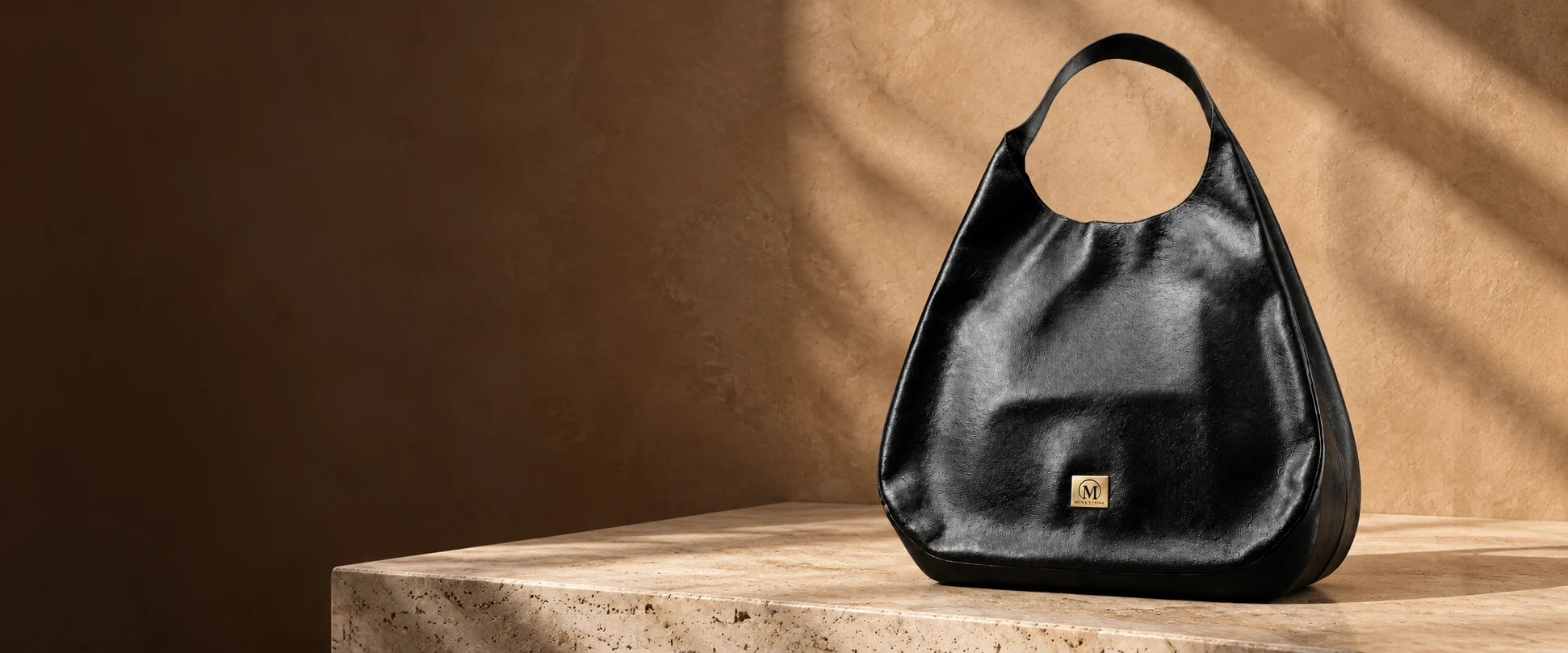 Oversized Leather Hobo Bag displayed on a travertine shelf against clay-coloured plaster